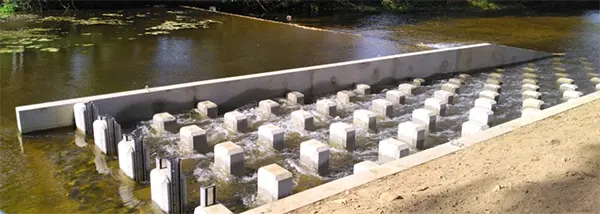 Vue d'une passe à poissons en escalier installée sur le Blavet à l'écluse de Quelennec à Languidic, permettant la migration des anguilles et poissons migrateurs